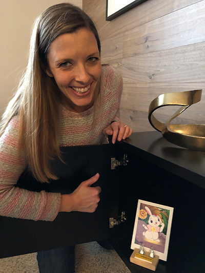 A woman sitting at a table with a picture of a cat.