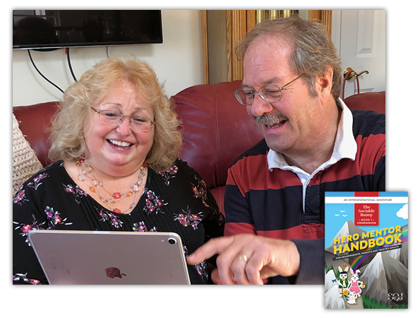 A man and woman sitting on the couch looking at an ipad.
