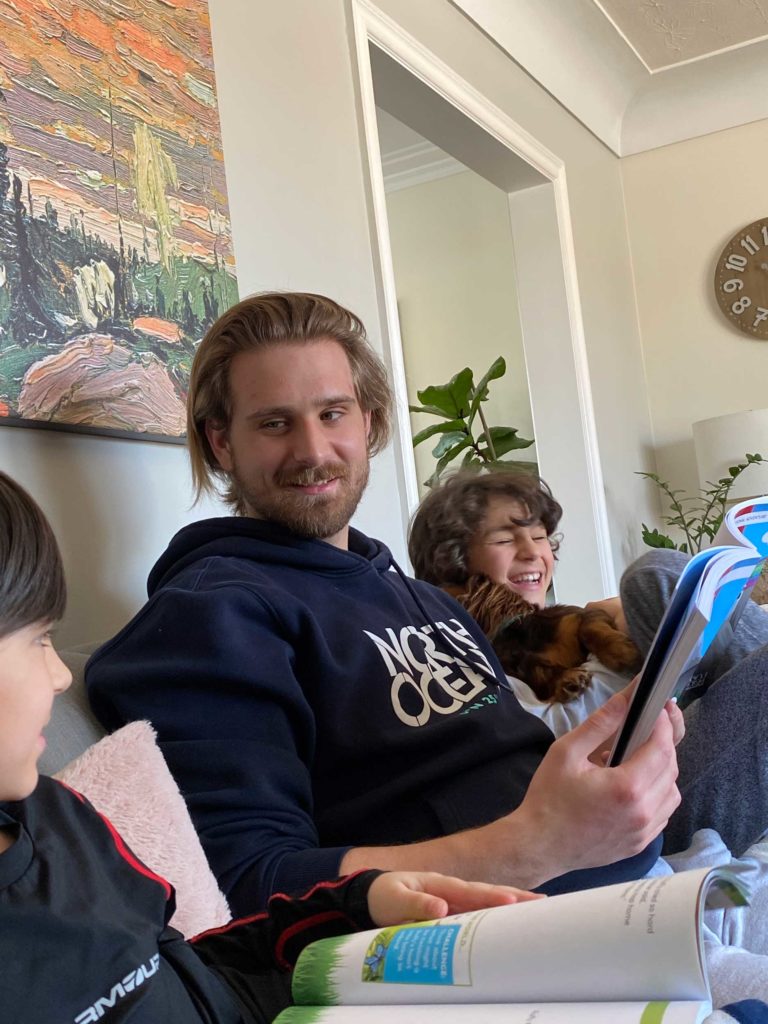 A man sitting on the couch with two children.